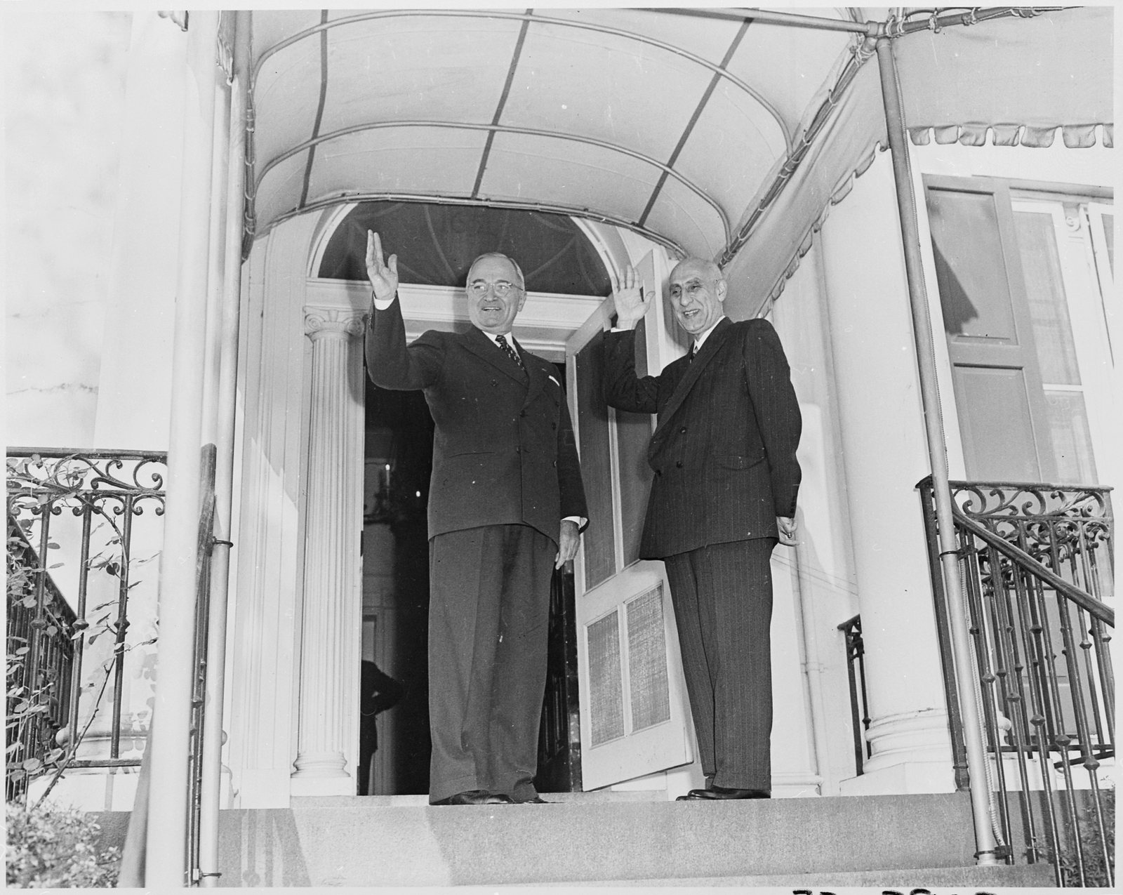 President Harry Truman and Iranian Prime Minister Mohammad Mossadegh smile and wave from the steps of Blair House in 1951.